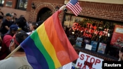 ay pride flag at a vigil outside The Stonewall Inn on Christopher Street