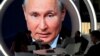 Participants of the St. Petersburg International Economic Forum gather near an electronic screen showing Russian President Vladimir Putin, who speaks during a session of the forum in St. Petersburg, Russia.