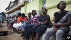 Voters sit and wait three hours after biometric identification machines had broken down, halting voting at a polling station, in Accra, Ghana, Friday, Dec. 7, 2012.