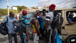 Warga Haiti yang dideportasi dari AS mencoba naik transportasi umum setelah meninggalkan Bandara Internasional Toussaint Louverture, di Port au Prince, Haiti, Senin, 20 September 2021. (AP Photo/Rodrigo Abd)