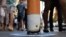 Shoppers walk past a bollard painted to represent a cigarette butt to raise awareness about new no smoking zones in Sydney, Sept. 26, 2016. A new program designed for indigenous Australians is helping lower their high rates of smoking.
