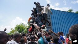 Residents overtake a truck loaded with relief supplies in Vye Terre, Haiti, Aug. 20, 2021.