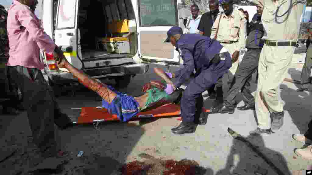 Des policiers transportent le suspect blessé dans l&#39;attentat à l&#39;extérieur de l&#39;académie de la police de Mogadiscio, en Somalie, le mercredi 9 mars 2016.