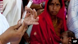 FILE - In this undated GAVI photo, an auxiliary nurse midwife prepares a vaccine shot at a health clinic in Purani Panapur, India.