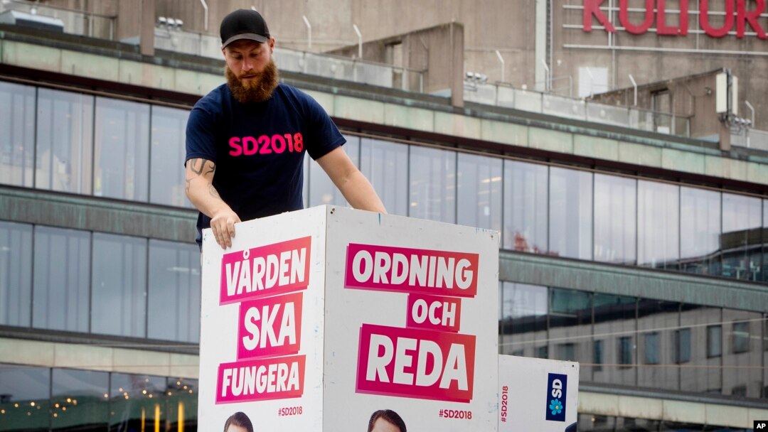 Election posters of the Sweden Democrats are put up by a party member in Stockholm, Aug. 30, 2018. The poster for the Sept. 9, 2018, election reads, "Welfare must work" and "Law and order." 