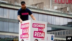 Election posters of the Sweden Democrats are put up by a party member in Stockholm, Aug. 30, 2018. The poster for the Sept. 9, 2018, election reads, "Welfare must work" and "Law and order." 