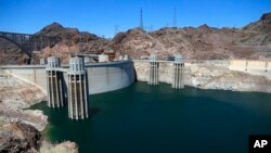 FILE - The low level of the water line is shown on the banks of the Colorado River at the Hoover Dam in Hoover Dam, Arizona, May 31, 2018.