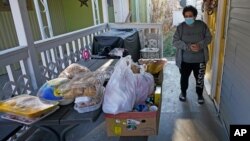 Evelyn Maysonet looks at the food delivery from the Weber-Morgan Health Department Tuesday, Nov. 24, 2020, in Ogden, Utah. Maysonet has been isolating with her husband and son in their Ogden home since all three tested positive for COVID-19 over a week…