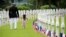 A U.S. Marine Corps soldier walks with a girl through headstones prior to a Memorial Day commemoration at the Aisne-Marne American Cemetery in Belleau, France.