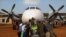 Des volontaires congolais poussent un avion de l'ONU le 25 juillet 2002