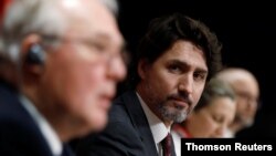 Canada's Prime Minister Justin Trudeau listens to Minister of Public Safety and Emergency Preparedness Bill Blair during a news conference on Parliament Hill in Ottawa, Ontario, May 1, 2020.