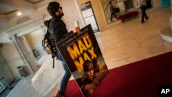 FILE - A spectator arrives at the Maria Victoria cinema to watch ''Mad Max. Fury Road'' during the 63rd San Sebastian Film Festival, in San Sebastian, northern Spain, Sept. 18, 2015.