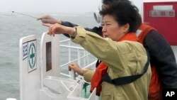 South Korean President Park Geun-hye looks at the site where the Sewol sank from aboard a Coast Guard ship in waters off the southern coast near Jindo, South Korea, Thursday, April 17, 2014.