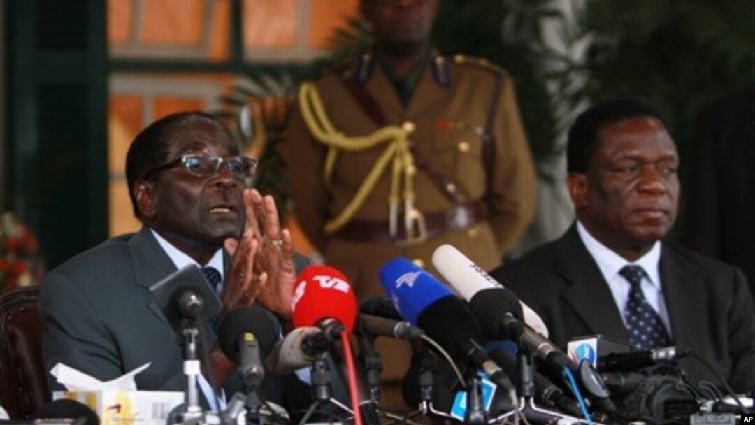 FILE: Zimbabwean President Robert Mugabe, left, and Defense Minister Emmerson Mnangagwa, at State House press conference, Harare, July, 30, 2013.