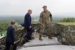 President Donald Trump and South Korean President Moon Jae-in, left, walk up to view North Korea from the Korean Demilitarized Zone from Observation Post Ouellette at Camp Bonifas in South Korea, Sunday, June 30, 2019.