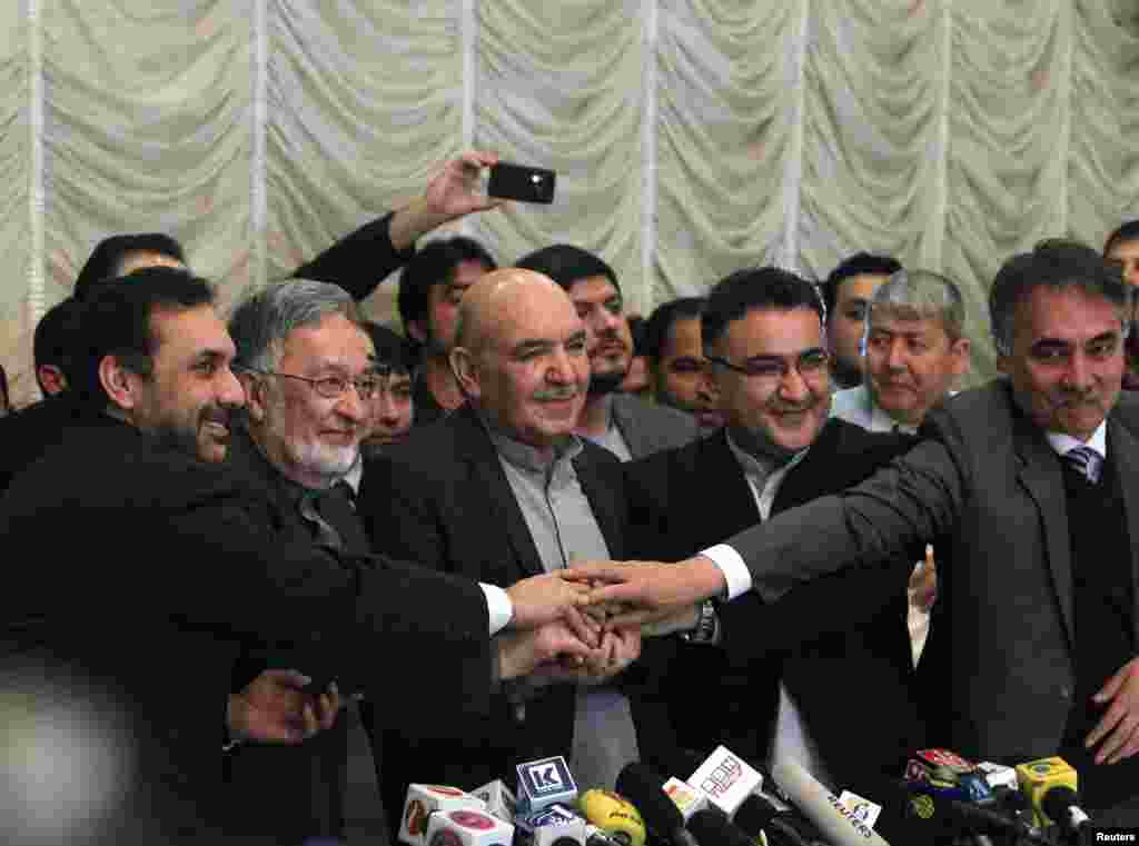 Presidential candidate Zalmai Rassoul (2nd L)&nbsp; shakes hands with Qayum Karzai (C) and their teams in Kabul, March 6, 2014.&nbsp; Karzai has announced he is withdrawing from the presidential race.