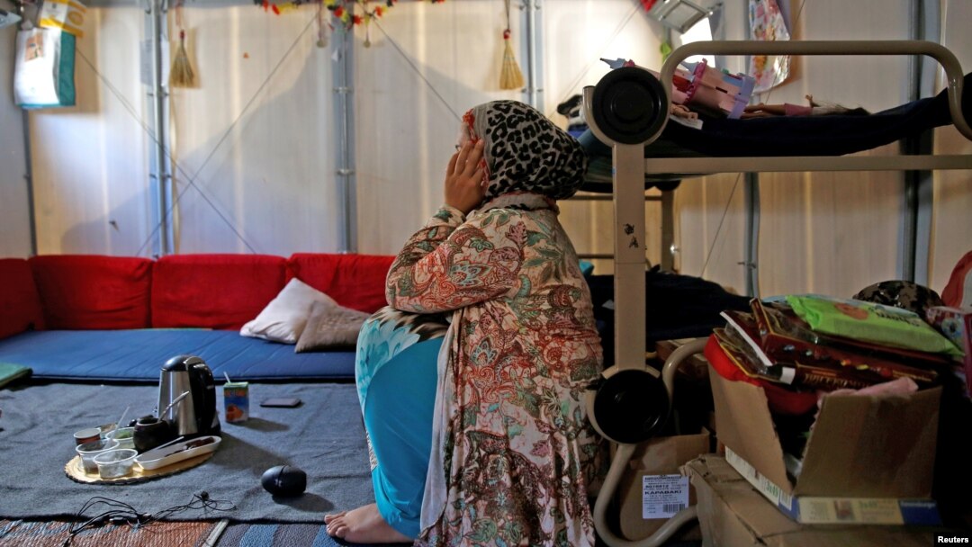 FILE - Syrian refugee Walaa, 26, sits inside her family's tent at the Souda municipality-run camp on the island of Chios, Greece, Sept. 7, 2016. 