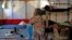 FILE - Syrian refugee Walaa, 26, sits inside her family's tent at the Souda municipality-run camp on the island of Chios, Greece, Sept. 7, 2016. 