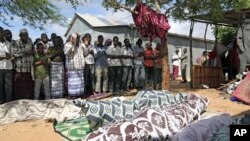 Relatives pray for the bodies of seven people killed during a raid by Islamists in Somalia's capital Mogadishu, May 8, 2012. 