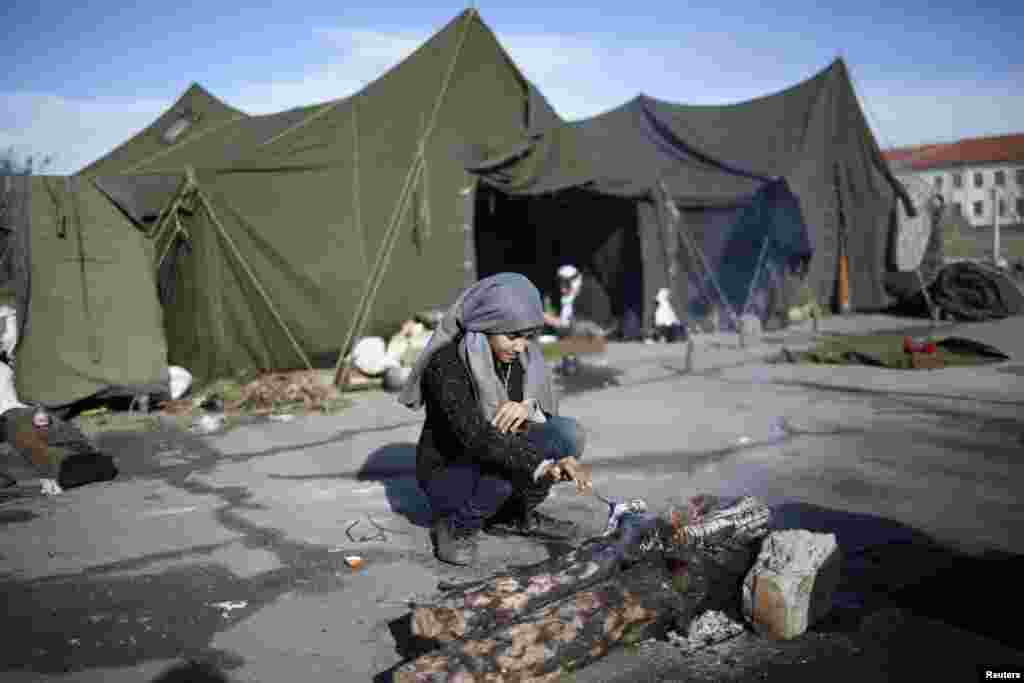 Seorang anak perempuan Suriah menyiapkan api di depan tenda di kamp pengungsian di Harmanli, 280 km (173 mil) Sofia timur, 9 Desember 2013. REUTERS/Pierre Marsaut