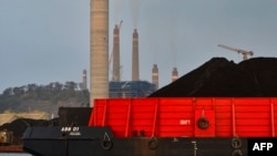 (FILE) A barge carrying coal at the dock next to the Suralaya coal-fired power plant in Indonesia.