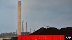 FILE - his picture taken on October 31, 2023 shows a barge carrying coal at the dock next to the Suralaya coal-fired power plant in Cilegon, Indonesia's Banten province.