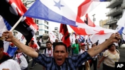 FILE - A demonstrator carries a Panamanian flag during a protest against U.S. policies in Latin America, in Panama City, April 9, 2015. On Wednesday, a U.S. special envoy urged Panama to stop Iranian ships from flying its flag, which allows Tehran to evade Washington's sanctions.