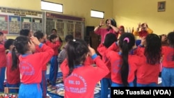 Kelompok paralegal Mekarjaya memimpin lagu terkait perlindungan anak dalam lomba mewarnai untuk murid PAUD di kelurahan Mekarjaya, Kota Bandung, Rabu, 31 Oktober 2018. (Foto: Rio Tuasikal/VOA) 