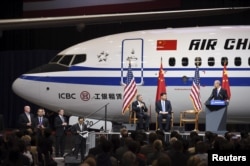 Presiden China Xi Jinping (tengah) dan Ray Conner (kiri), presiden perusahaan pesawat terbang komersial Boeing, menyaksikan Wakil Kepala Eksekutif Perusahaan Boeing Dennis Muilenburg (kanan) berdiri di podium, pasca kunjungan Xi di Everett, Washington, (23/9).