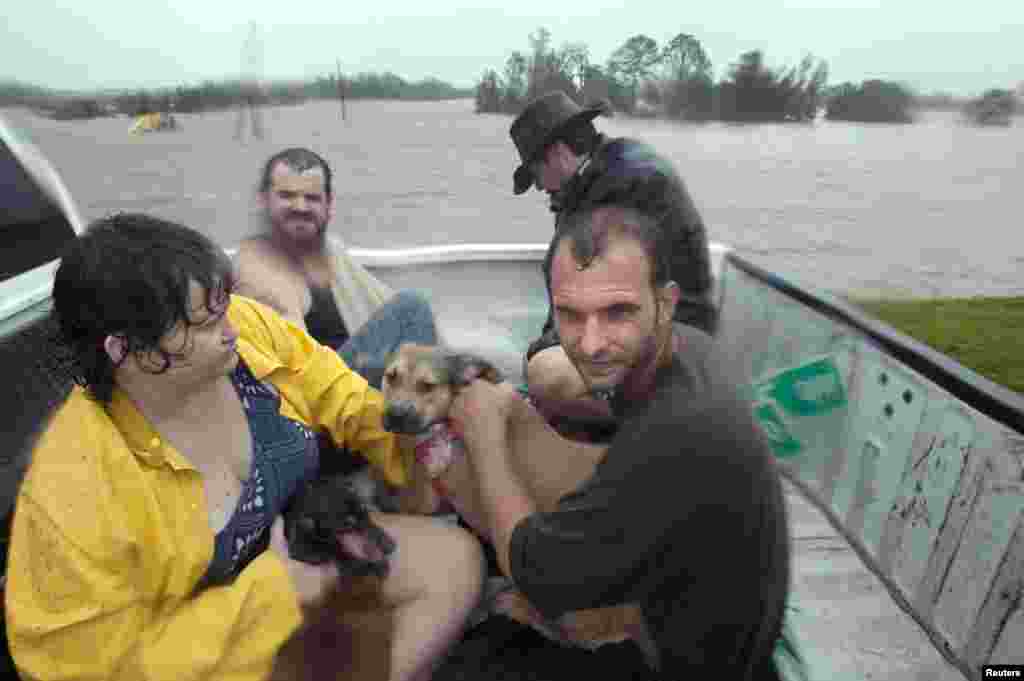 Residents of Plaquemines Parish who were rescued from their flooded homes sit in the back of a pickup truck during Hurricane Isaac in Braithwaite, Louisiana August 29, 2012.