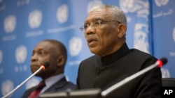FILE -Guyana's President David A. Granger, right, with Guyana's Vice President and Foreign Minister Carl Greenidge, delivers remarks during a press briefing at the United Nations headquarters in New York, Sept. 29, 2015. 