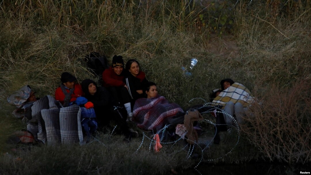 ARCHIVO - Migrantes venezolanos que buscan asilo en Estados Unidos se reúnen a orillas del río Bravo, mientras la Guardia Nacional de Texas bloquea el cruce en la frontera entre Estados Unidos y México, en Ciudad Juárez, México. 27 de noviembre de 2023.