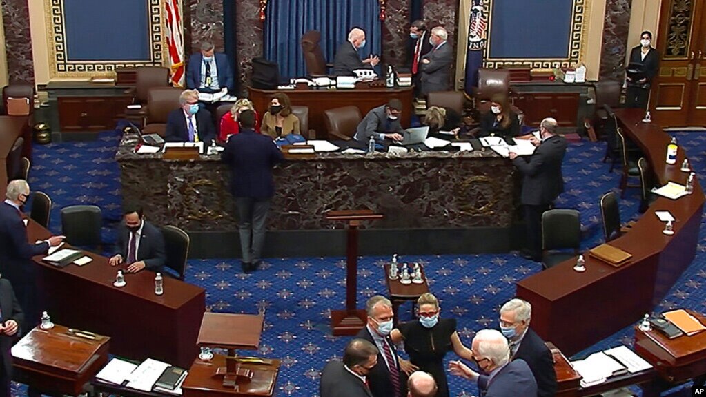 资料照片：国会视频截图显示议员和工作人员在参议院会场商谈。(2021年2月13日)(photo:VOA)