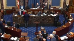 En esta imagen de video, legisladores y miembros del personal se reúnen en el piso del Senado en el Capitolio de EE. UU. en Washington, el 13 de febrero de 2021.