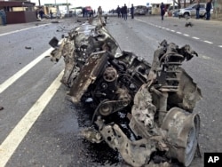 FILE - The wreckage of a suicide bomber's car is seen near a traffic police check point near Derbent in Russia's northern Caucasus region of Dagestan, Feb. 15, 2016.