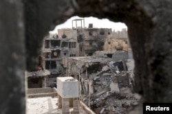 FILE - Damaged buildings are pictured after clashes between members of the Libyan pro-government forces and the Shura Council of Libyan Revolutionaries, an alliance of former anti-Gaddafi rebels who have joined Islamist group Ansar al-Sharia, in Benghazi, Libya,