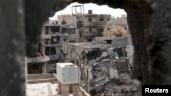 Damaged buildings are pictured after clashes between Libyan pro-government forces and the Shura Council of Libyan Revolutionaries, an alliance of former anti-Gaddafi rebels who have joined Islamist group Ansar al-Sharia, in Benghazi, Libya, April 1, 2015.