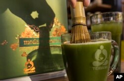 Barista di Teavana mengaduk matcha dengan pengaduk tradisional yang terbuat dari bambu.