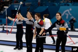 South Korea's women's curling team celebrate after beating Russian athletes during their match at the 2018 Winter Olympics in Gangneung, South Korea, Feb. 21, 2018.