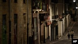 Residentes de Pamplona, España, usando mascarilla caminan por la vacía calle Javier, el 24 de octubre de 2020, en medio de nuevas medidas contra el COVID en la provincia de Navarra, en el norte del país.
