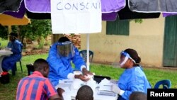 FILE - Ugandan health workers speak to civilians before carrying out the first vaccination exercise against the Ebola virus in Kirembo village, near the border with the Democratic Republic of Congo in Kasese district, Uganda, June 16, 2019. 