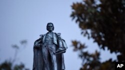 A 100-foot monument to former U.S. vice president and slavery advocate John C. Calhoun towers over a downtown square Tuesday, June 23, 2020, in Charleston, S.C.