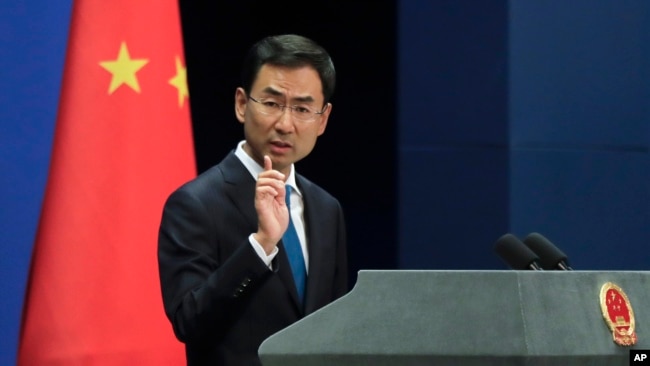 FILE - Chinese Foreign Ministry spokesman Geng Shuang gestures as he speaks during a daily briefing at the Ministry of Foreign Affairs office in Beijing, Sept. 4, 2017.