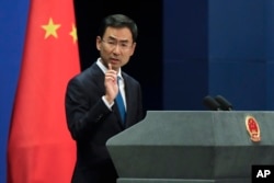 FILE - Chinese Foreign Ministry spokesman Geng Shuang gestures as he speaks during a daily briefing at the Ministry of Foreign Affairs office in Beijing, Sept. 4, 2017.