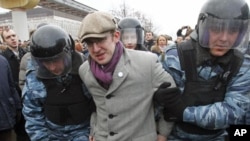 Riot police detain a protester during a rally near the state-controlled TV channel NTV tower in Moscow, March 18, 2012.