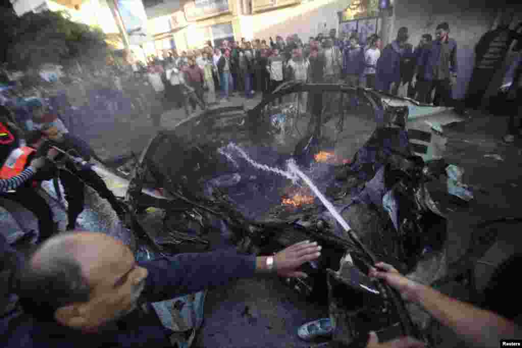 Palestinians surround the car carrying Ahmed al-Jaabari that was hit by an Israeli air strike, Gaza City, November 14, 2012. 