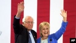 Democratic presidential candidate Hillary Clinton and Sen. Bernie Sanders wave to supporters with during a rally in Portsmouth, N.H., where Sanders endorsed her for president, July 12, 2016.
