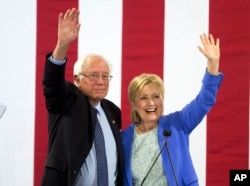FILE - Hillary Clinton and Sen. Bernie Sanders wave to supporters during a rally in Portsmouth, N.H., where Sanders endorsed her for president, July 12, 2016.