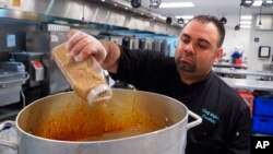 FILE - Majed Abdalraheem, 29, a Syrian refugee and chef with meal delivery service Foodhini, prepares a dish at Union Kitchen in Washington, May 18, 2018.