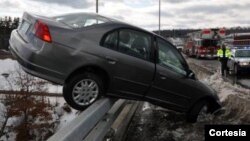 En esta imagen proporcionada por el departamento de Bomberos de Hudson, Nueva Hampshire, se ve a un auto balanceándose en la valla protectora del puente Sagamore.